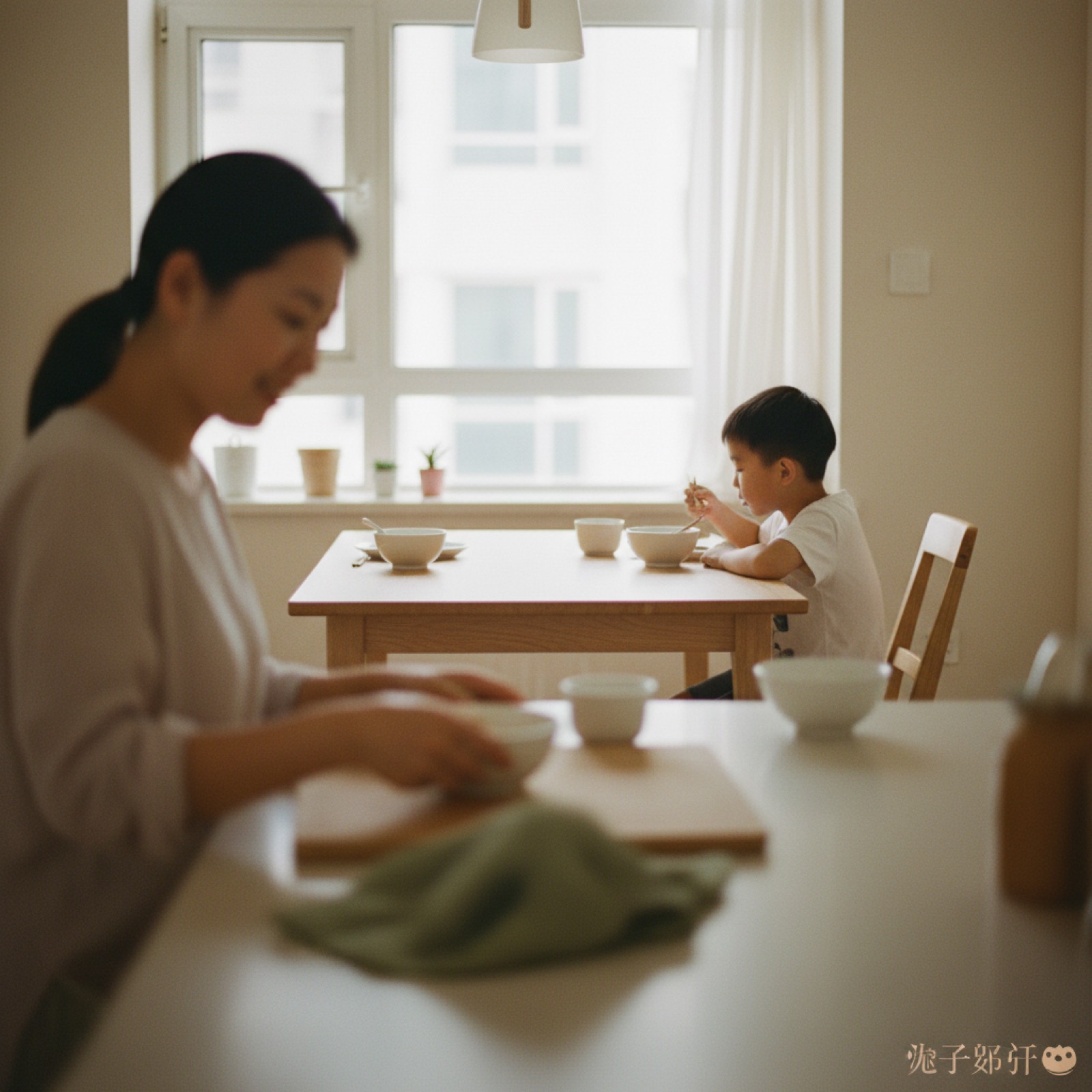 清晨厨房妈妈准备早餐看孩子吃,孩子侧背影