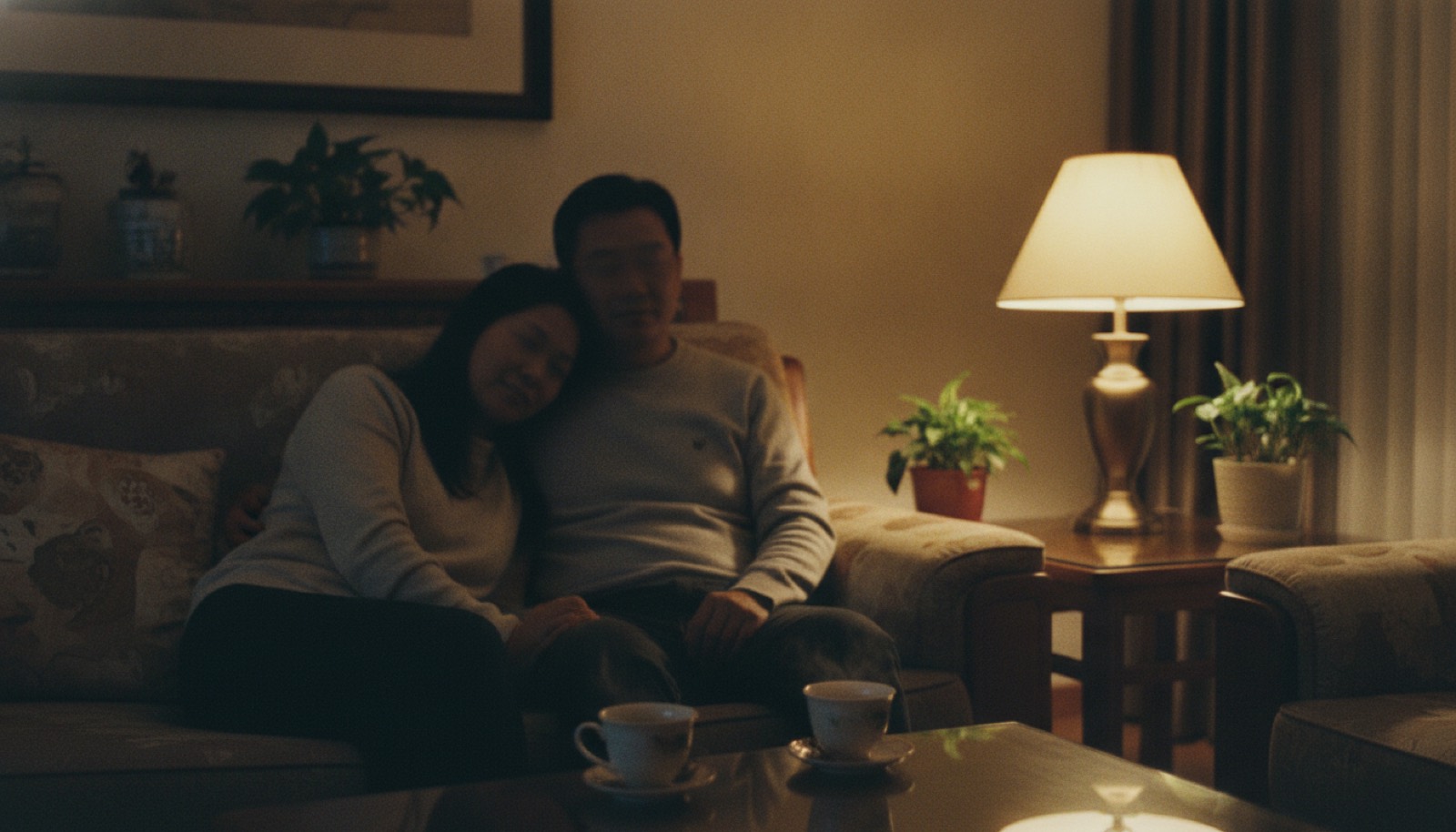 深夜客厅沙发妈妈靠在爸爸肩上桌上两杯热茶