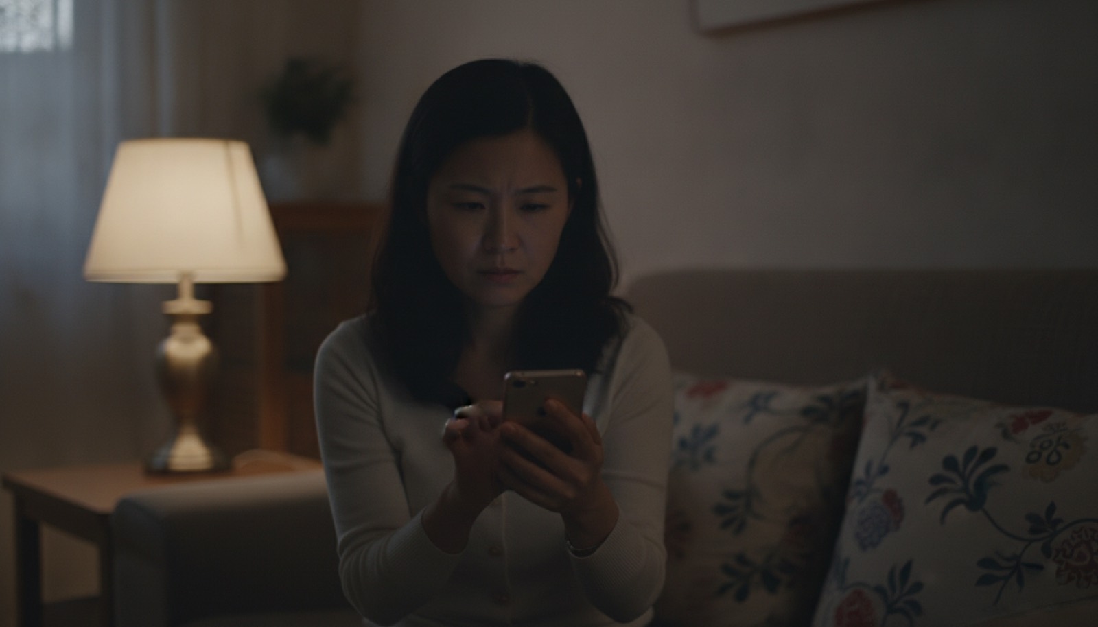 夜晚沙发妈妈盯着手机神情从兴奋转凝重