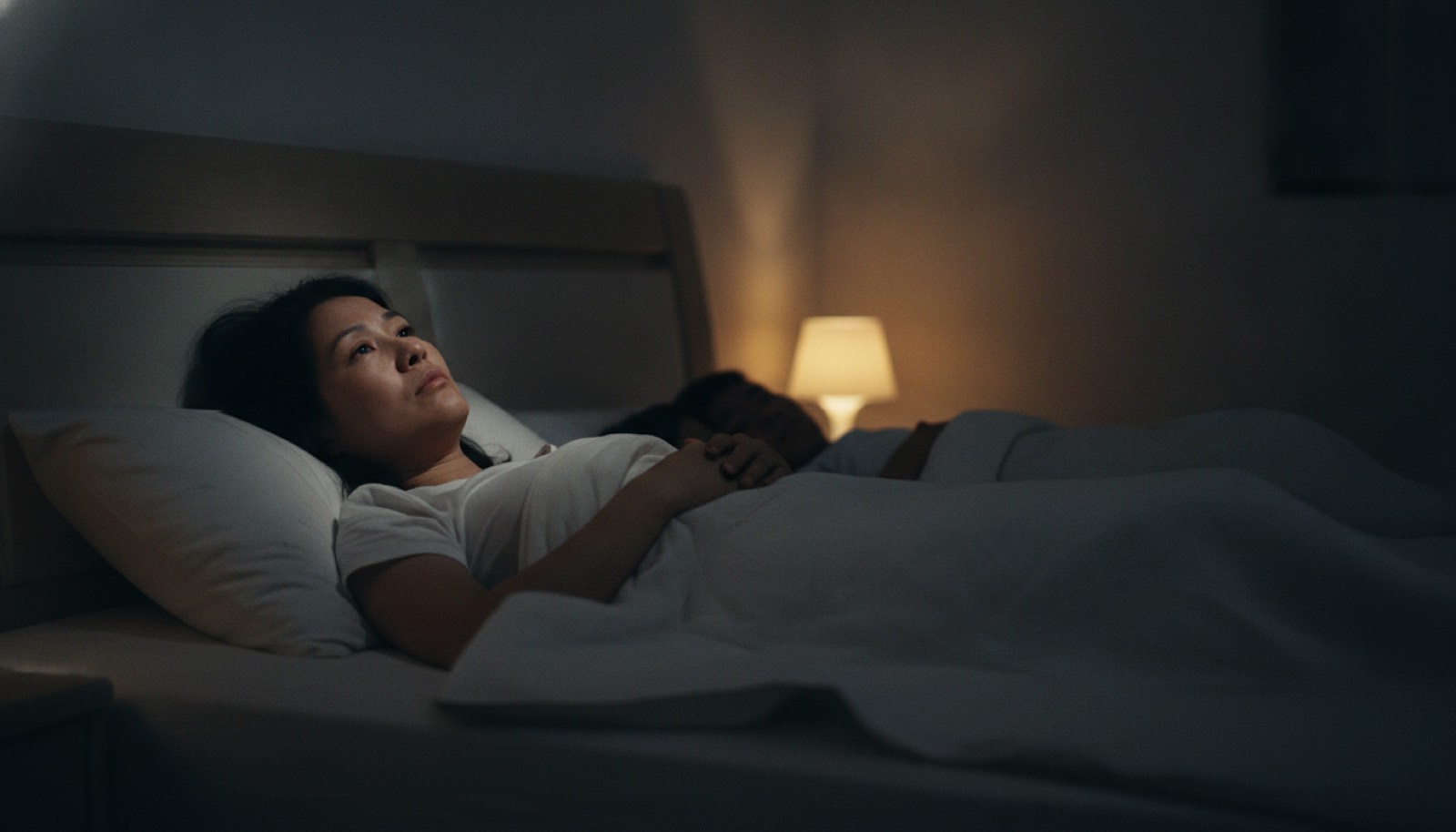 深夜卧室妈妈躺床上望天花板愧疚出神
