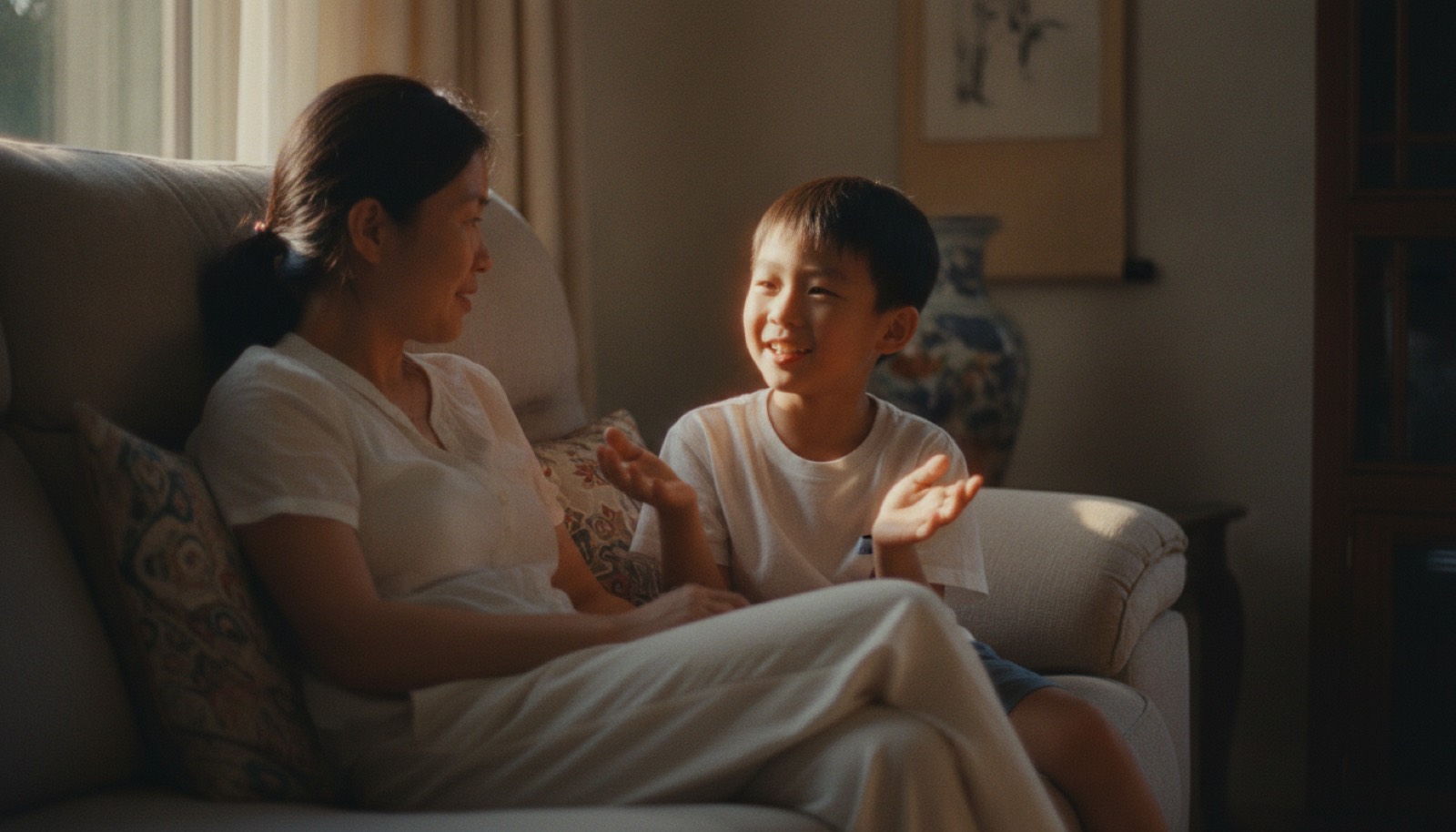 傍晚沙发妈妈和孩子轻松聊天孩子笑着比划